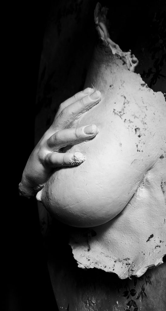 moulage de seins généreux d'une mère de 40 ans, sur lequel se pose la main aimante de son fils, symbole d'amour et de connexion.